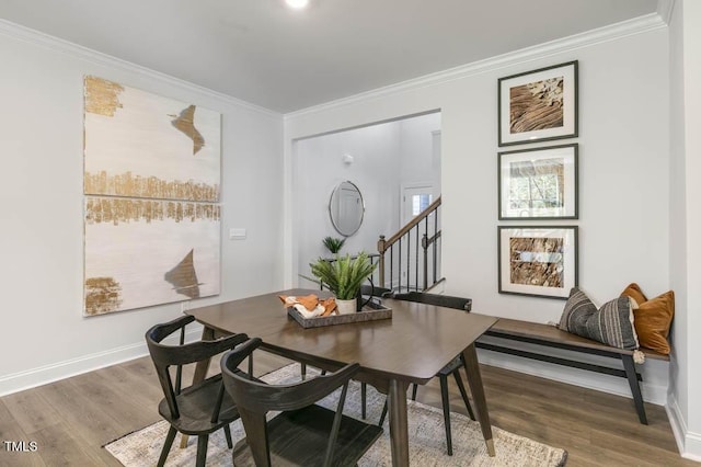 dining space with ornamental molding and wood-type flooring