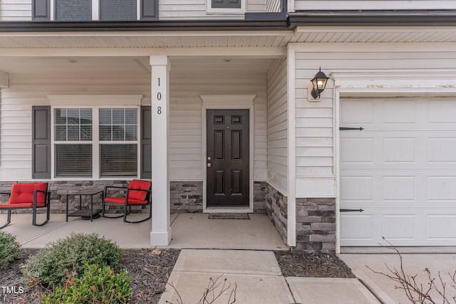 doorway to property with a porch and a garage