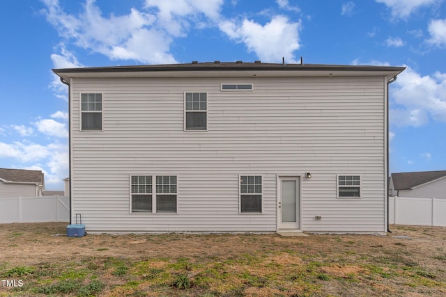 rear view of house featuring a lawn