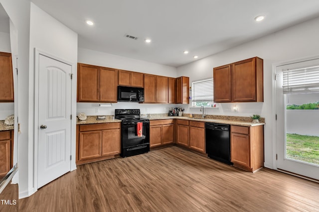 108 Bonnie Girl Ct, Lillington, NC 27546 - kitchen with black appliances, visible vents, brown cabinets, a sink, and wood finished floors