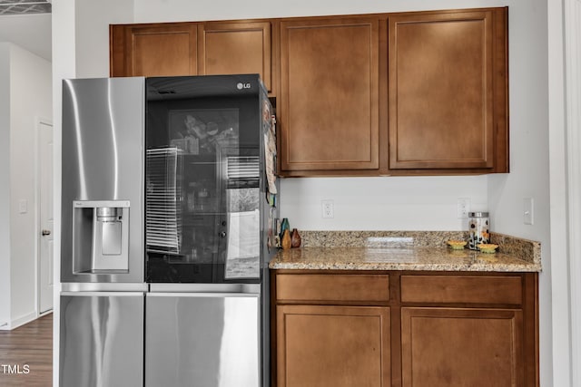 108 Bonnie Girl Ct, Lillington, NC 27546 - kitchen with brown cabinets, wood finished floors, stainless steel fridge, and light stone countertops