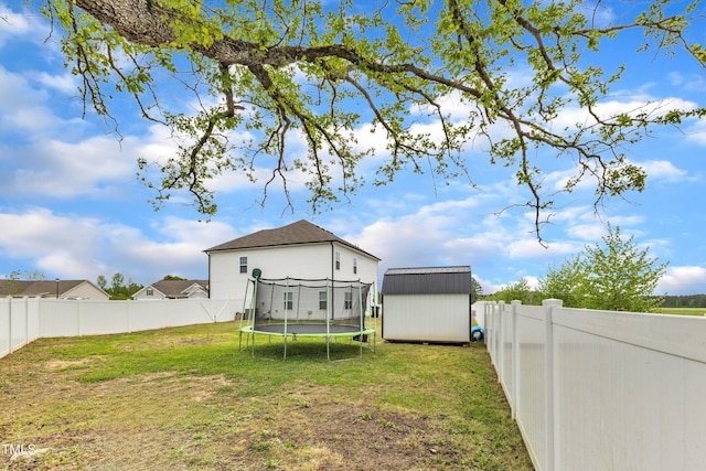 108 Bonnie Girl Ct, Lillington, NC 27546 - back of house featuring a storage shed, a trampoline, a lawn, a fenced backyard, and an outbuilding