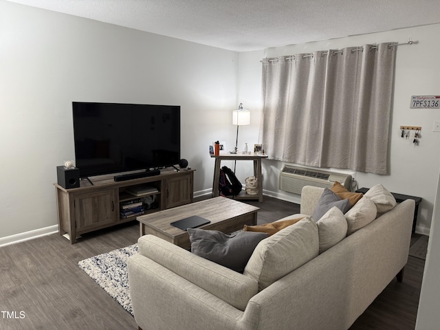 living room featuring dark wood-type flooring, an AC wall unit, and a textured ceiling