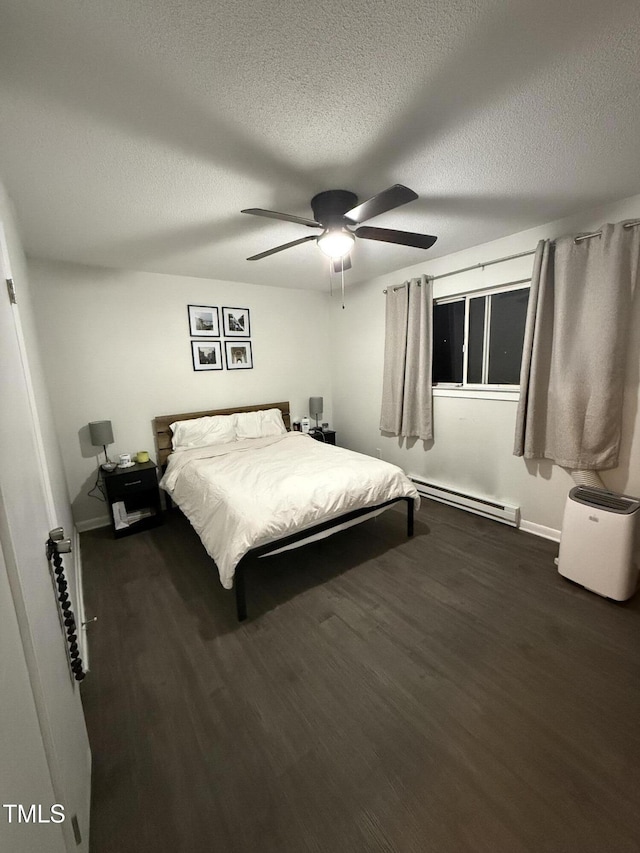 bedroom with ceiling fan, dark wood-type flooring, a baseboard radiator, and a textured ceiling