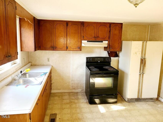 kitchen with white refrigerator, black electric range, and sink