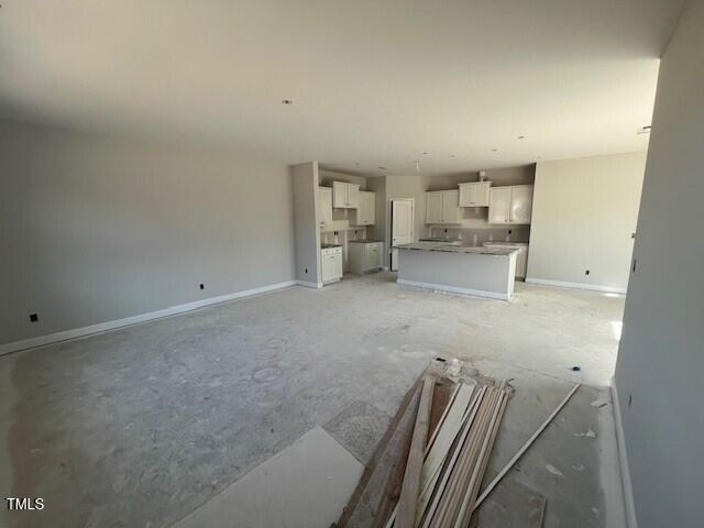 unfurnished living room featuring baseboards