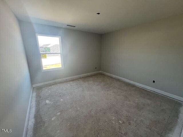 unfurnished room with visible vents and baseboards