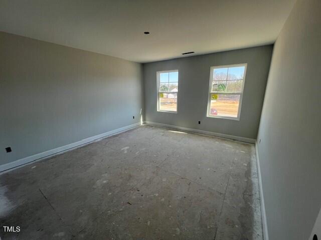 unfurnished room with baseboards