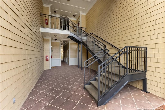 stairs featuring tile patterned floors and a high ceiling