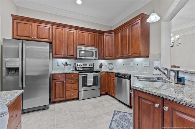 kitchen featuring sink, ornamental molding, appliances with stainless steel finishes, pendant lighting, and decorative backsplash