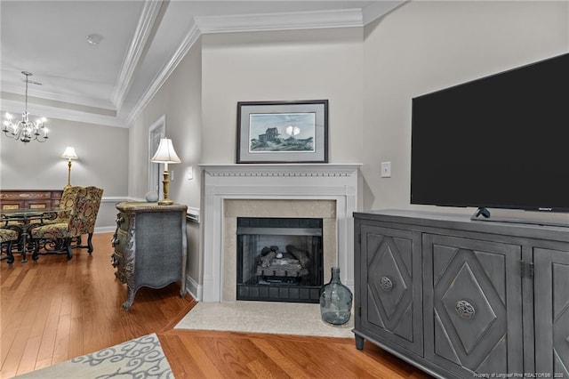 living room with wood-type flooring, a notable chandelier, and crown molding