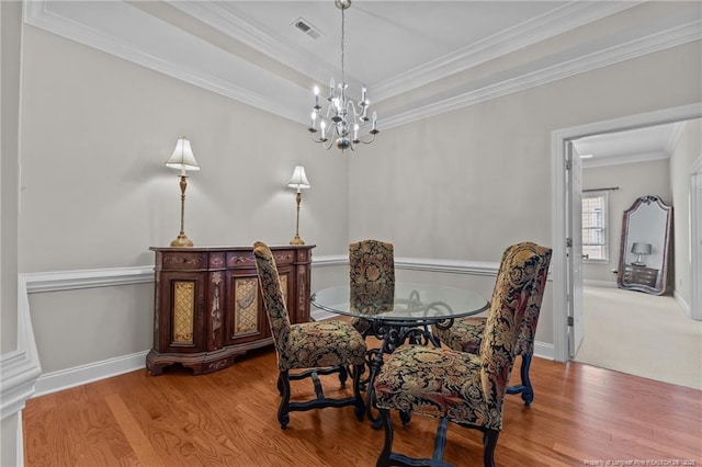 dining room featuring crown molding, a chandelier, and hardwood / wood-style floors