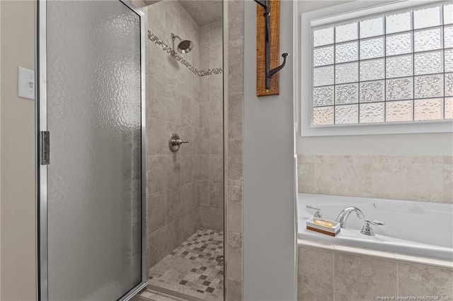 bathroom with plenty of natural light and separate shower and tub