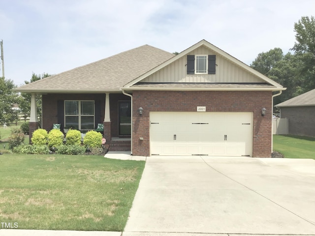 craftsman-style home featuring a garage, a front yard, and covered porch