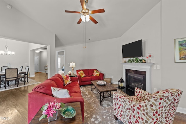 2001 Bunnfield Dr, Zebulon, NC 27597 - living room with wood finished floors, lofted ceiling, ceiling fan, a chandelier, and a fireplace with flush hearth