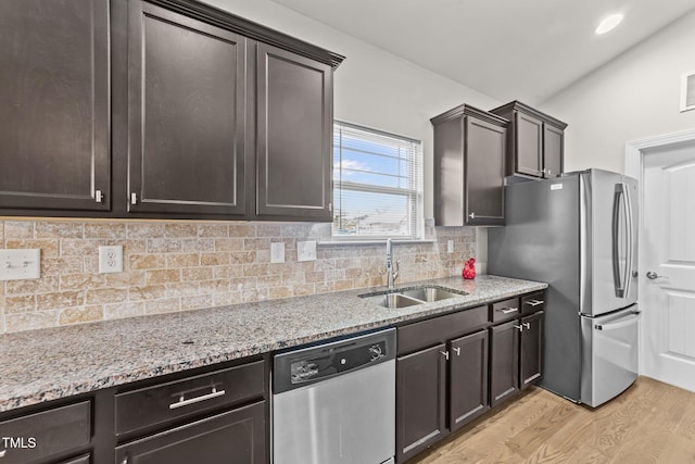 2001 Bunnfield Dr, Zebulon, NC 27597 - kitchen with stainless steel appliances, light wood-type flooring, light stone countertops, decorative backsplash, and lofted ceiling