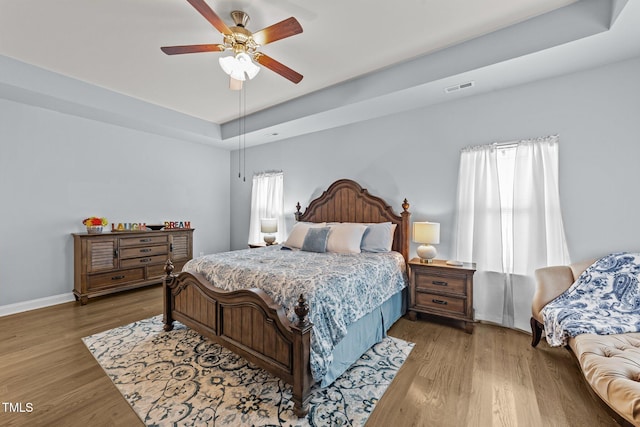 2001 Bunnfield Dr, Zebulon, NC 27597 - bedroom featuring wood finished floors, a tray ceiling, and ceiling fan