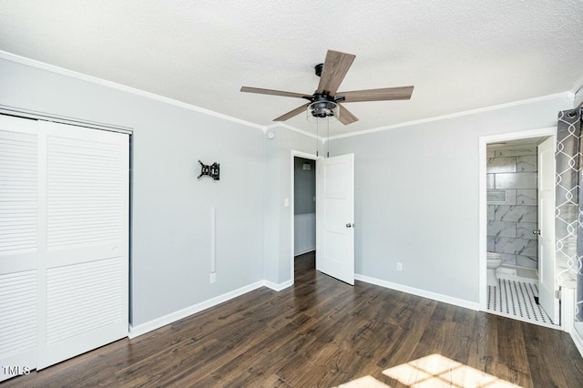 unfurnished bedroom featuring crown molding, a textured ceiling, dark hardwood / wood-style flooring, and a closet