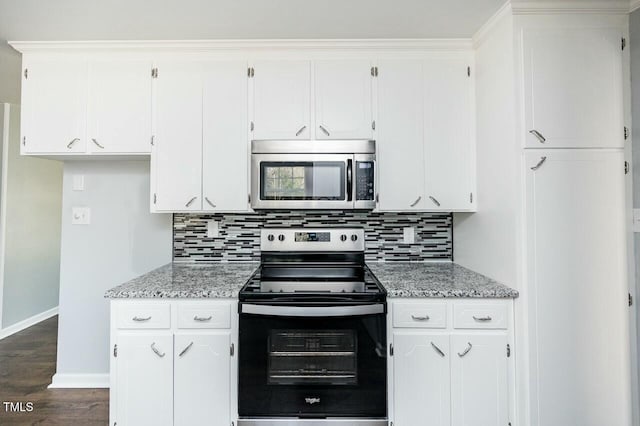 kitchen with light stone counters, appliances with stainless steel finishes, tasteful backsplash, and white cabinets