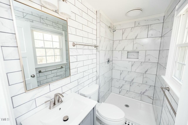 bathroom with tile walls, a tile shower, vanity, tasteful backsplash, and toilet