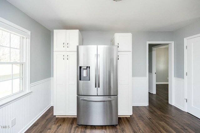 kitchen with stainless steel refrigerator with ice dispenser, dark wood-type flooring, and white cabinets