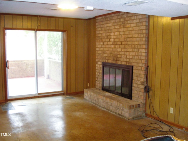 unfurnished living room with a fireplace and wood walls