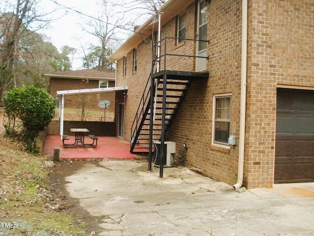 view of side of home with a garage and ac unit