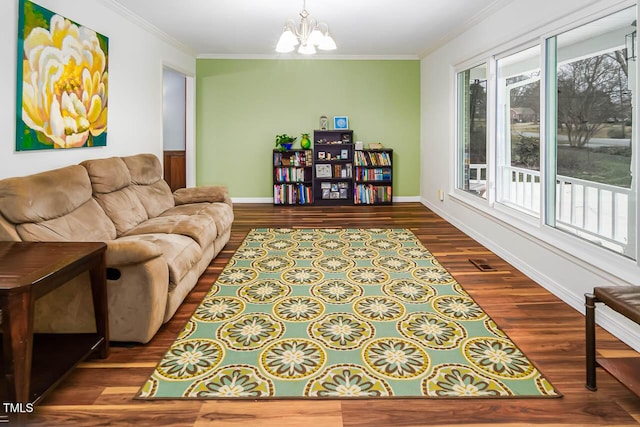 living room featuring crown molding, wood-type flooring, and a chandelier