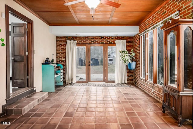 unfurnished sunroom featuring ceiling fan, wood ceiling, and french doors