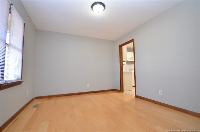 spare room with sink and light wood-type flooring