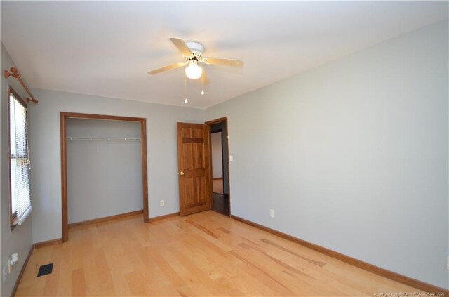 unfurnished bedroom with light hardwood / wood-style flooring, a closet, and ceiling fan