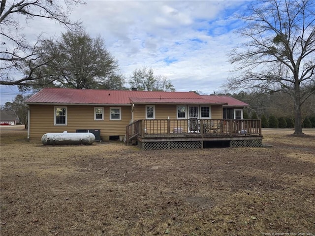 back of property with metal roof and a wooden deck