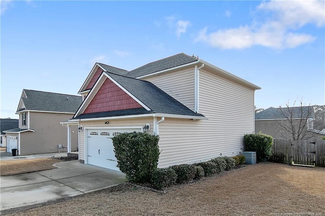 view of side of property featuring a garage and cooling unit