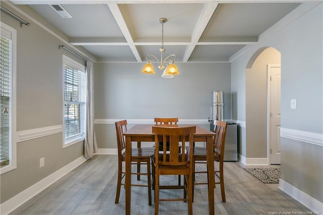 dining room featuring hardwood / wood-style flooring, beamed ceiling, coffered ceiling, and a notable chandelier