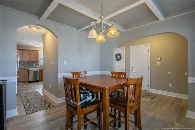 dining space with coffered ceiling, beam ceiling, and light wood-type flooring