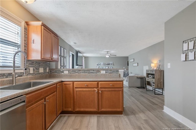 kitchen featuring sink, dishwasher, kitchen peninsula, ceiling fan, and decorative backsplash