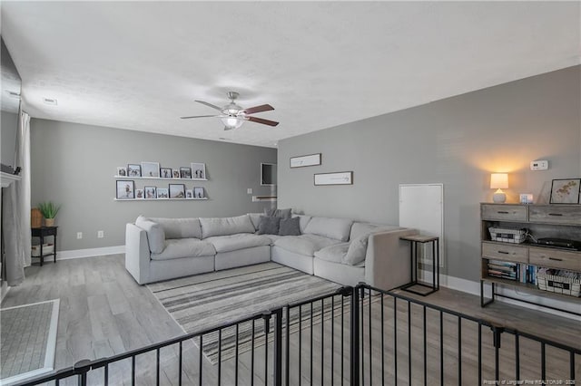 living room featuring wood-type flooring and ceiling fan