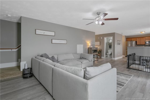 living room featuring ceiling fan and light hardwood / wood-style flooring