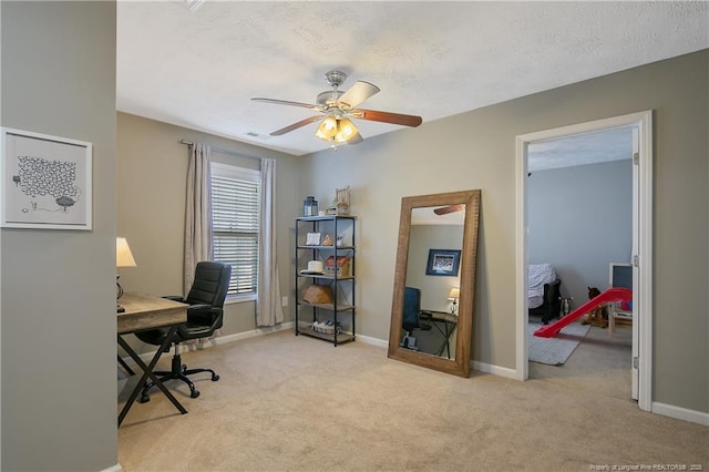 home office with a textured ceiling, light colored carpet, and ceiling fan