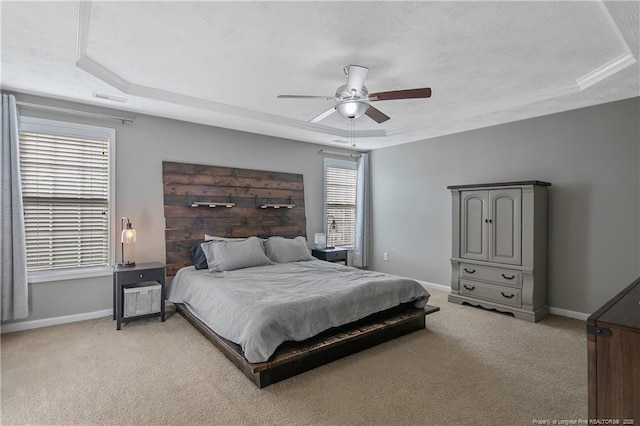 carpeted bedroom with a raised ceiling, ceiling fan, and a textured ceiling