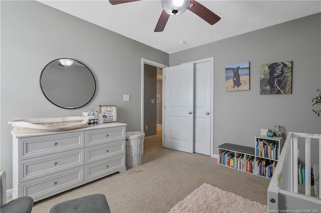 bedroom featuring light carpet, ceiling fan, and a closet