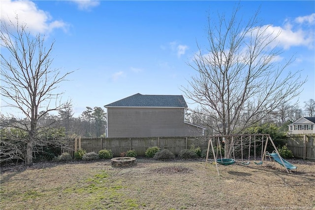 view of yard with an outdoor fire pit and a playground