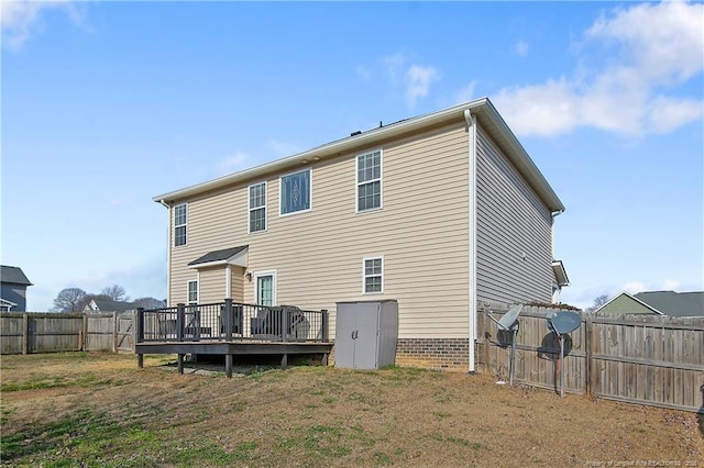 rear view of property featuring a yard and a deck