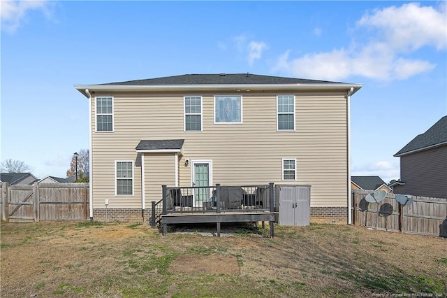 rear view of property with a wooden deck and a lawn