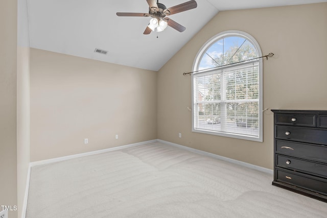 unfurnished bedroom featuring vaulted ceiling, light colored carpet, and ceiling fan