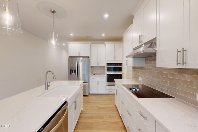 7117 Hubner Pl Unit 22, Cary, NC 27519 - kitchen featuring stainless steel appliances, under cabinet range hood, recessed lighting, white cabinetry, and decorative light fixtures
