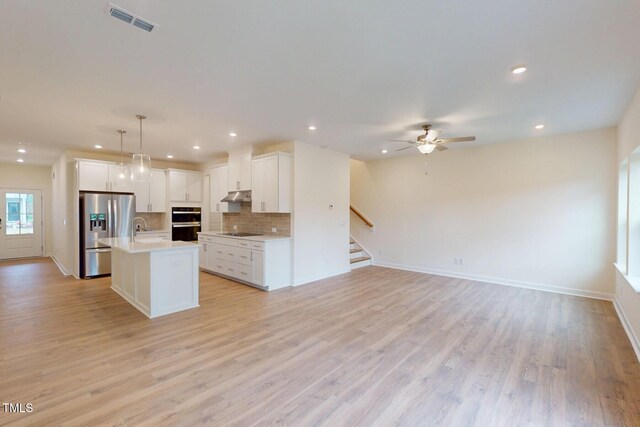 7117 Hubner Pl Unit 22, Cary, NC 27519 - kitchen featuring black appliances, open floor plan, a ceiling fan, light countertops, and tasteful backsplash
