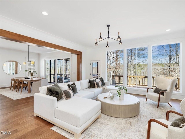 living room featuring a notable chandelier, crown molding, and wood-type flooring