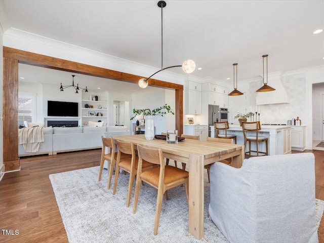 dining area featuring ornamental molding and light hardwood / wood-style floors