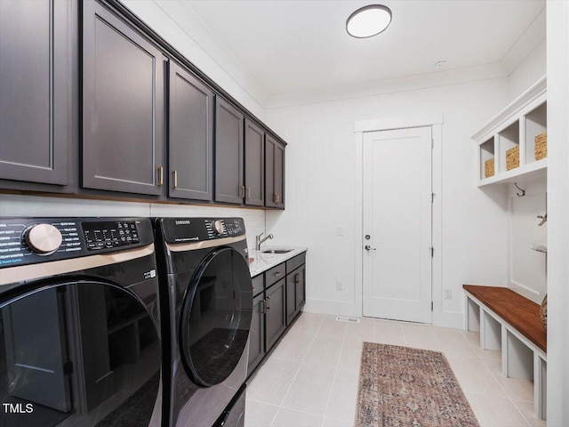 clothes washing area featuring cabinets, crown molding, separate washer and dryer, and sink